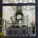 Workers inspect camera components in a clean room.